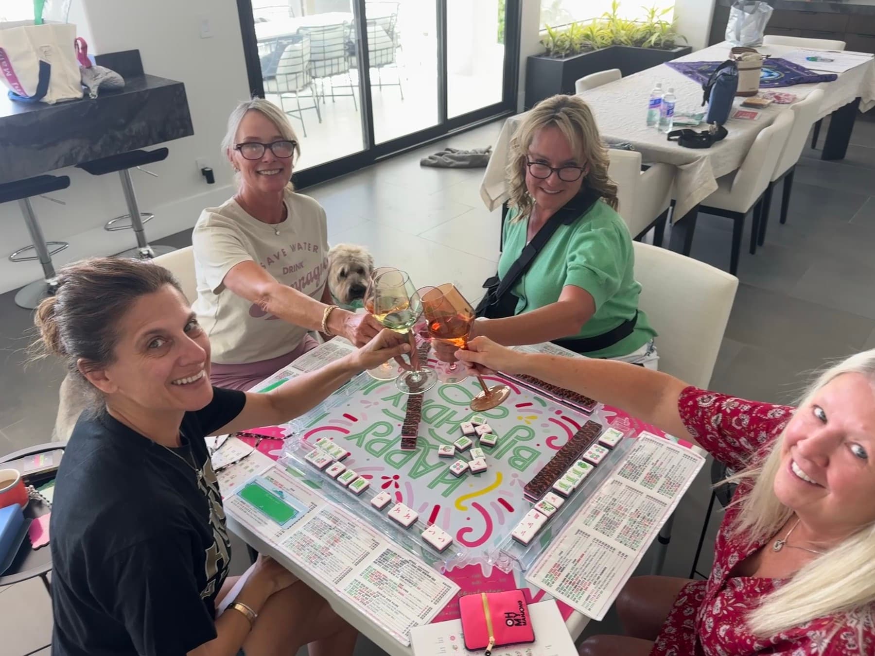 Players toasting with wine over a Happy Birthday mahjong mat at a Las Vegas Mahjong party